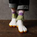 Person wearing long pink Tabi Socks 'Ajisai' with purple hydrangea pattern, paired with white Tabi Shoes 'SAIBU' featuring orange soles.