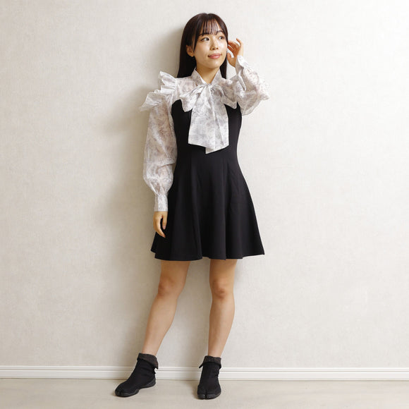 Lifestyle image of a woman wearing black KAMON tabi shoes, styled with a skirt in a simple, minimalist indoor setting.