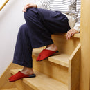 KASUMI red tabi slippers featuring a split-toe design and textured fabric, shown worn indoors.