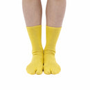Person wearing long yellow Tabi Socks " Pixel Densha ", front view