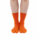 Person wearing long orange Tabi Socks " Pixel Shika ", front view