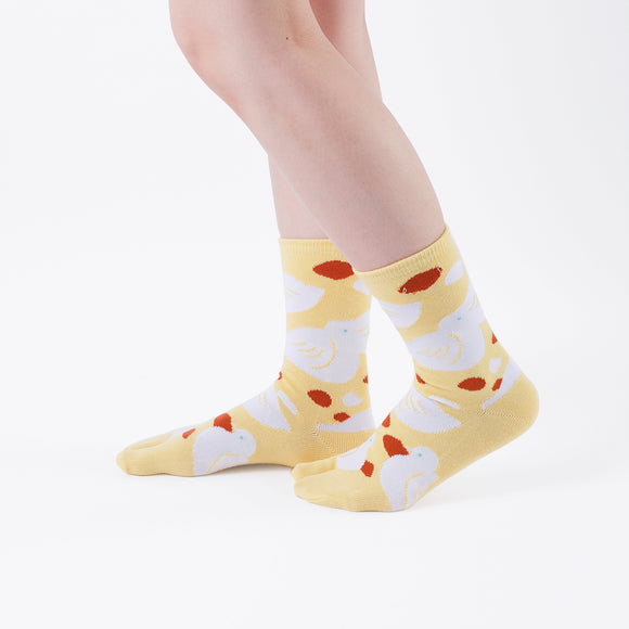 Person wearing long yellow Tabi Socks " Hato ", right side view