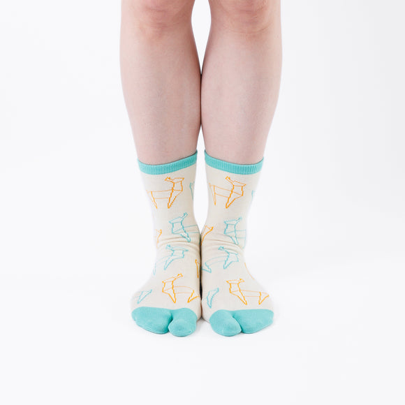 Person wearing long light yellow Tabi Socks " Shika Origami ", front view