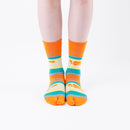 Person wearing long orange Tabi Socks " Densha ", front view