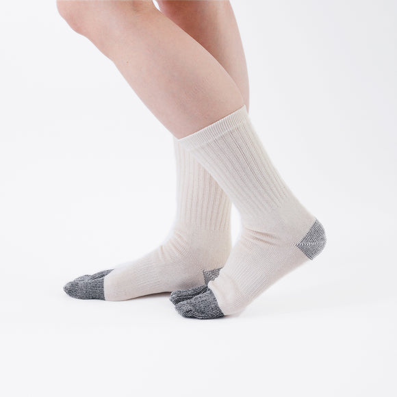 Person wearing beige Tabi Socks "NOBI NOBI", right side view