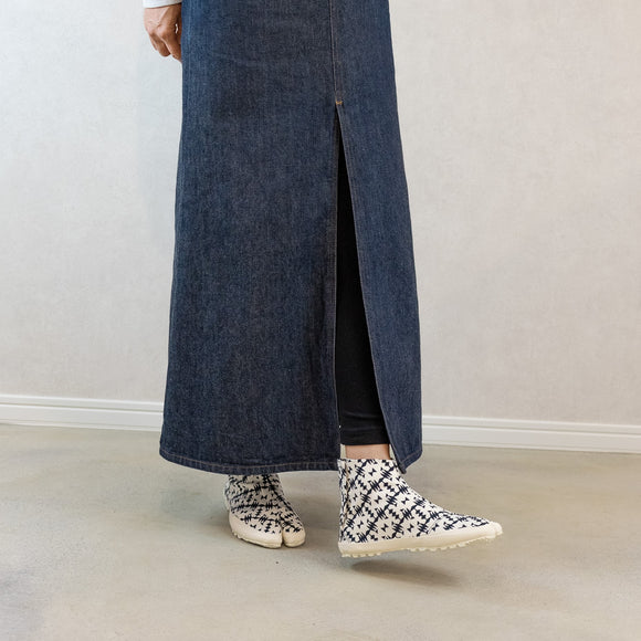 Indoor side view of black Tabi Shoes "TIGRE" styled with a long denim skirt and black leggings.