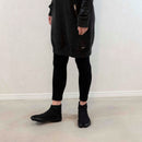 Person wearing black Tabi Shoes "U-ten" in a casual standing pose indoors